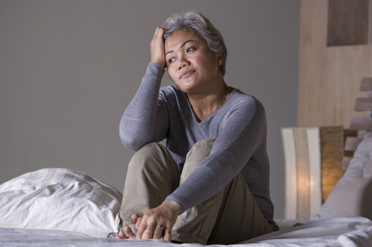 desperate 40s - 50s mature lady, dramatic lifestyle home portrait of attractive sad and depressed middle aged woman with grey hair on bed feeling upset suffering depression and anxiety